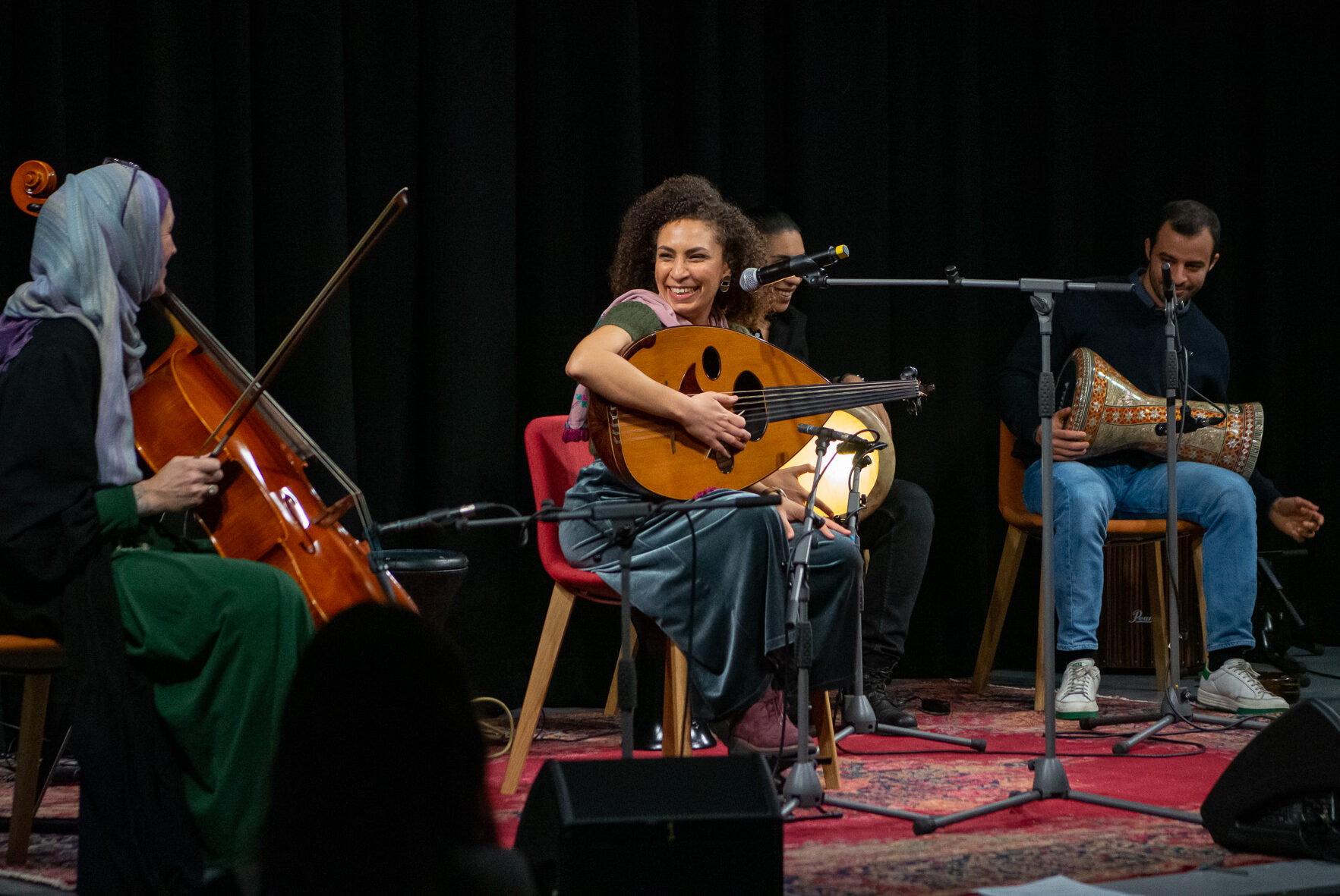 A group of people playing instrument on the stage