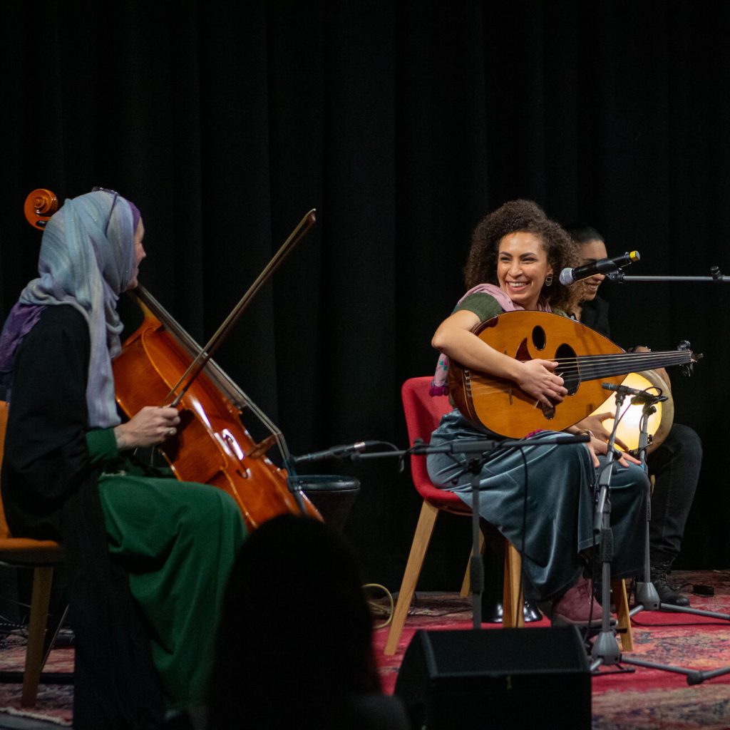 A group of people playing instrument on the stage