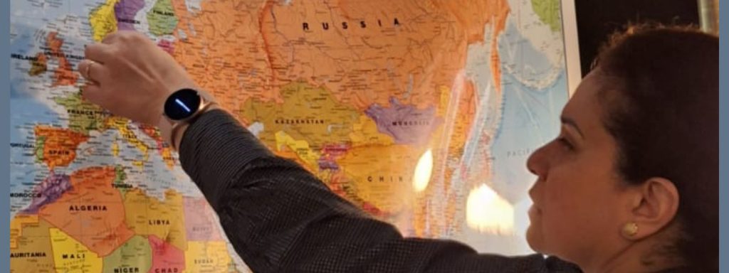A woman pointing to a world map