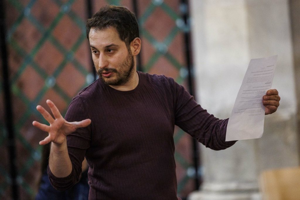 A man doing a speech and holding a piece of paper