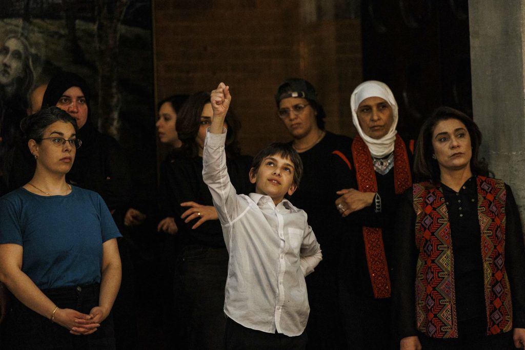 a child raising his hand in a group of people
