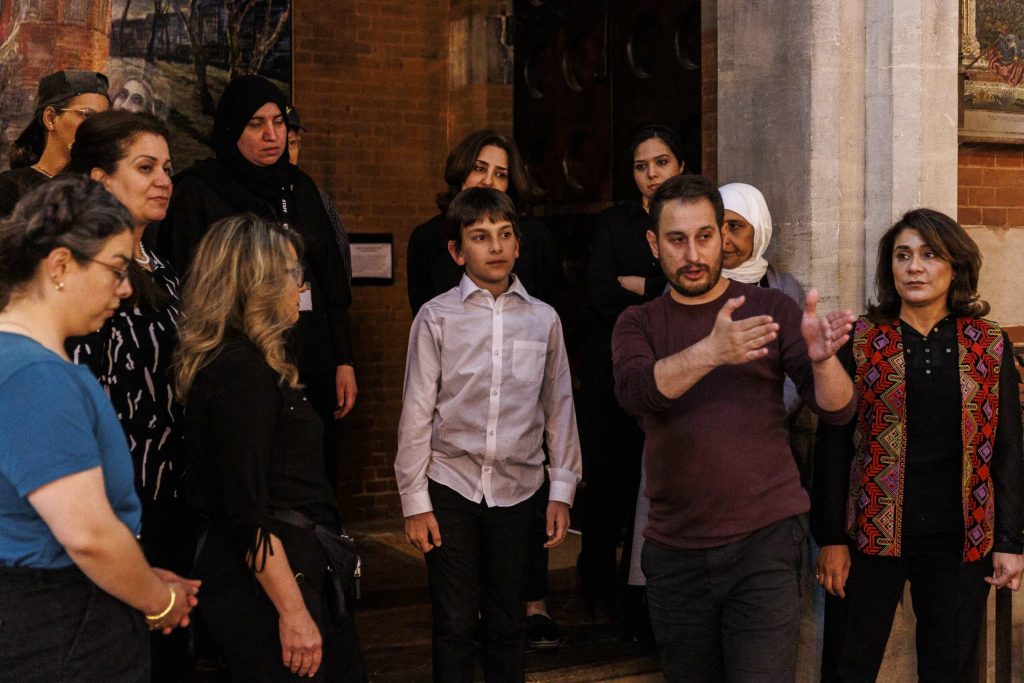 A group of people standing around each other and a man showing the direction to the boy